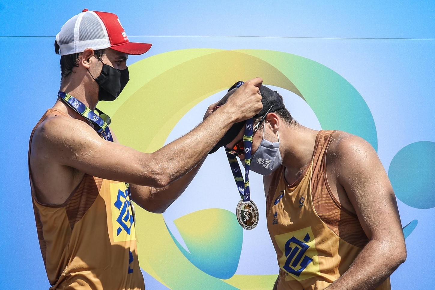 Andre places the gold medal around George's neck during the awarding ceremony